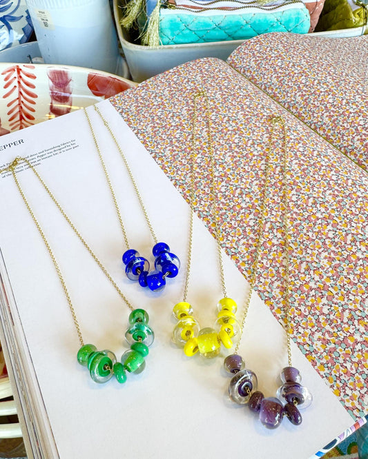 Lifesaver Glass Bead Necklaces
The graduated sizes and varied shapes of these playful “Lifesaver” beads create wonderful movement when worn. Some designs feature joyful monochromatic color combinations, while others mix vibrant colors for a more expressive, energetic look. Each necklace has its own personality, from softly coordinated to bright and unexpected.