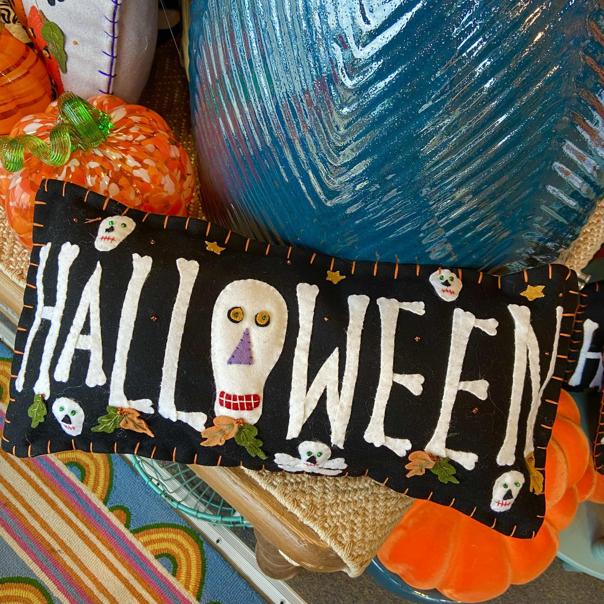 Decorative Halloween pillow with skeleton face design on a colorful background
